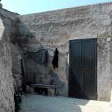 Prima di raggiungere la riva notiamo sulla sinistra una piccola dimora in pietra affacciata sul mare, il cui unico elemento esteriore � una porta in ferro, accanto a cui sono appesi alcuni ritagli di stoffa